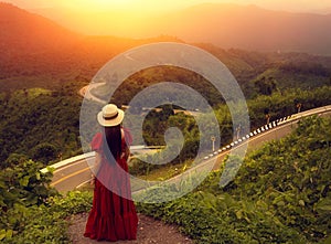 Traveler woman in red dress walking on view point of Nan province