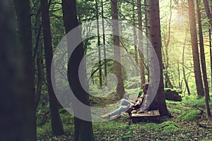 Traveler woman rests in a mysterious and surreal forest photo