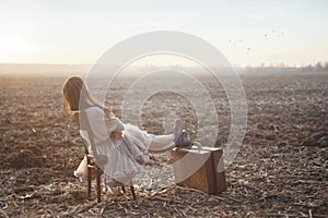 traveler woman rests sitting on a chair in the middle of nature, concept of freedom and well-being