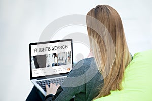 Traveler woman searching for a flight on laptop
