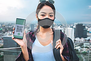 Traveler woman shows health passport of vaccination certification on phone at cafe.Close up of view hands women holding smartphone