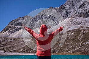 Traveler woman standing in freedom with arms up showing two fingers happy and looking beautiful view amazing mountains at outdoor,