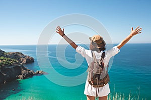 Traveler woman standing on sea cliff.