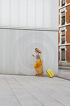 Traveler woman with suitcase looking for her flat in the center