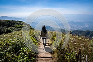 Traveler woman walking in the middle of abundance natural forest in the mountain