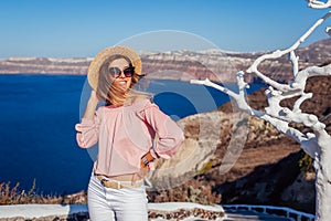 Traveler woman walking on Santorini island, Greece enjoying landscape. Happy girl enjoys Caldera view