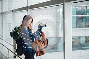 Traveler young asian girl with backpack taking a photo with her digital camera