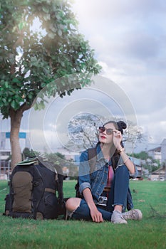 A traveler young girl sitting under a tree relax time and looin