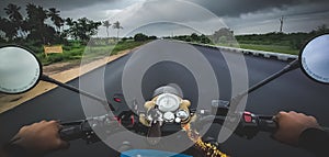 Traveler Young man riding on a motorcycle on Highway with Beautiful dramatic weather. Hands of motorcyclist on a Highway road.