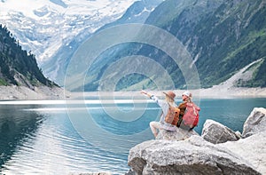 Travelers couple look at the mountain lake. Travel and active life concept with team.