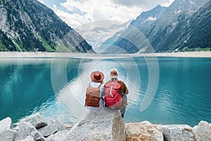 Travelers couple look at the mountain lake. Travel and active life concept with team.