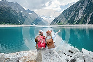 Travelers couple look at the mountain lake. Travel and active life concept with team. Adventure and travel in the mountains region