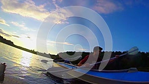 Travelers kayaking at sunset, action camera, underwater, slow-mo