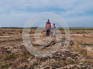 Travelers mother daughter raising hands on mountain summit spending time together walking climbing enjoying scenic