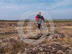 Travelers mother daughter raising hands on mountain summit spending time together walking climbing enjoying scenic