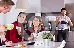 Travelers planning tourist itinerary in hostel kitchen photo