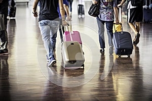 Travelers with suitcases walking through the airport photo
