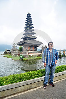 Travelers thai men travel visit and respect praying of Pura Ulun Danu Bratan in Bali, Indonesia