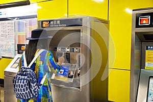 Travelers thai woman buying ticket train subway from automatic sale ticket box in Mong Kok railway station at Kowloon in Hong Kong