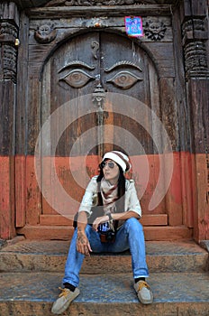 Travelers thai women journey and travel visit ancient art eyes of wisdom buddha on antique wooden wood door in nepali architecture