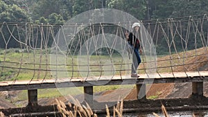 Travelers thai women visit walking on wooden suspension bridge in Pang Oung