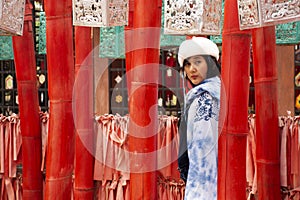 Travelers thai women wearing indigo shawl travel visit and take photo with red torii in Wat Phu Sa Ma temple in Ban Kung Mai Sak