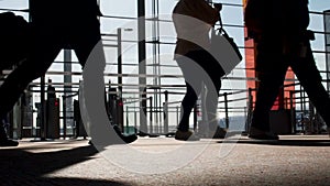 Travelers walking at airport terminal, carrying luggage, boarding slow motion