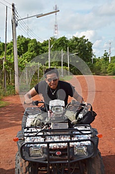 Travelers young thai men biking and riding ATV motorcycle auto or All Terrain Vehicle or quad bike in mountain forest of activity