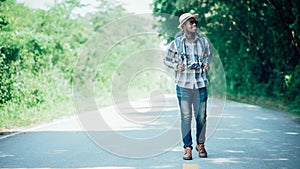 Traveling african male tourist backpacker walking on the highway road.Adventure travel concept