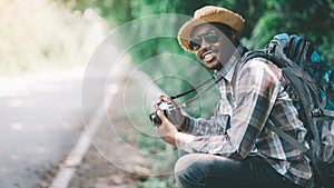 Traveling african male tourist backpackers taking photo side of the highway road.Adventure travel concept