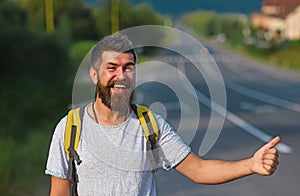 Traveling by autostop, having summer trip. Autostop travel. Man with strict face and beard travelling by hitchhiking