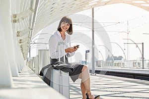 Traveling business woman with smart phone and luggage