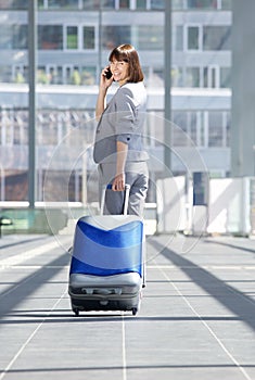 Traveling business woman walking with bag and mobile phone