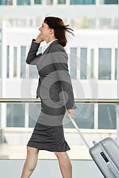Traveling business woman walking and talking on cell phone