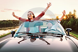Traveling by car - happy couple in love go by cabriolet car in s
