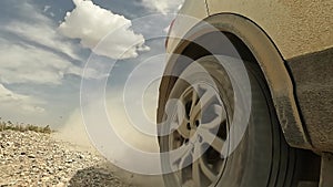 Traveling by car in Kyrgyzstan. Close-up of a car driving on a dirt rocky road