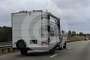 Traveling by caravan trailer on a freeway road, family vacation, holiday trip in motorhome RV.