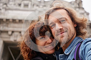 Traveling couple making selfie on city background