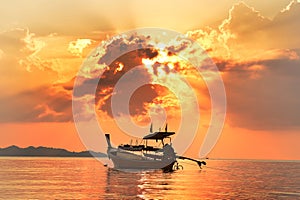 Traveling empty thai longtail boat under golden sun rays photo