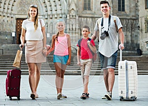 Traveling family walking along city