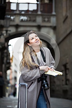 Traveling girl searching for the direction using a booklet in th