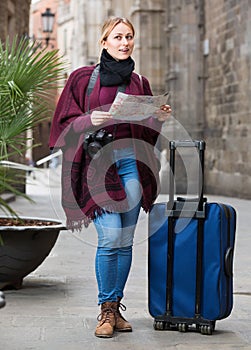 Traveling girl searching for direction using paper map