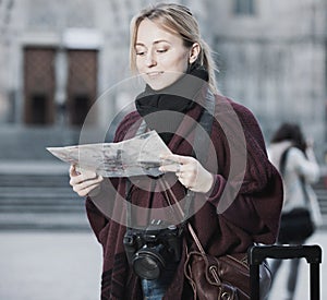 Traveling girl searching for direction using paper map