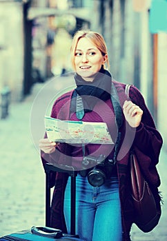 Traveling girl searching for direction using paper map