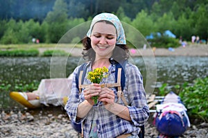 Traveling girl smells yellow flowers taken from nature