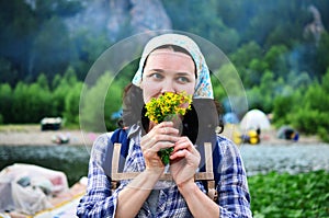Traveling girl smells yellow flowers taken from nature