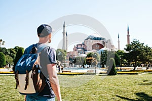 A traveling man with a backpack in Sultanahmet Square near the famous Aya Sofia mosque in Istanbul in Turkey. Travel