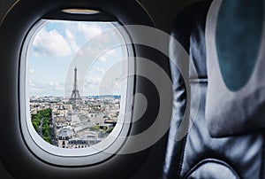 Traveling Paris, France famous landmark and travel destination in Europe. Aerial view Eiffel Tower through airplane window