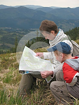 Traveling people reading map on mountains