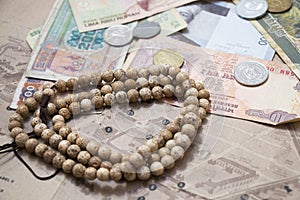 Traveling retro still life closeup with map, money, coins, buddhist mala bracelet.